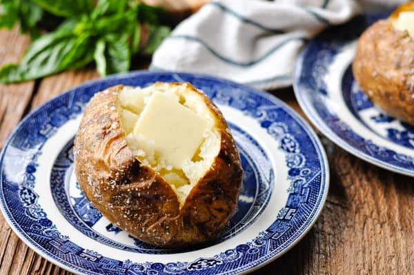 Horizontal shot of baked potatoes on a blue and white plate