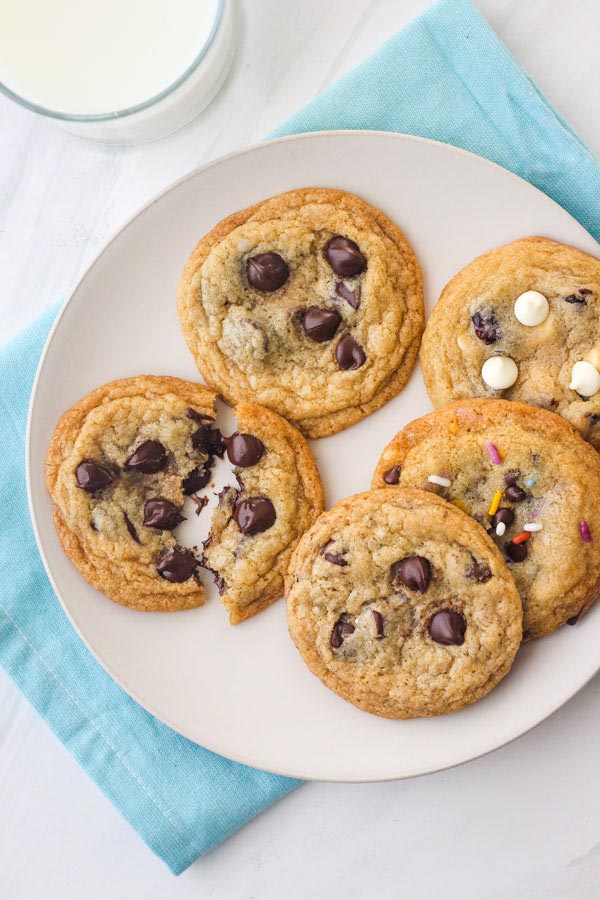 Aerial view of a plate of cookies with a glass of cold milk.