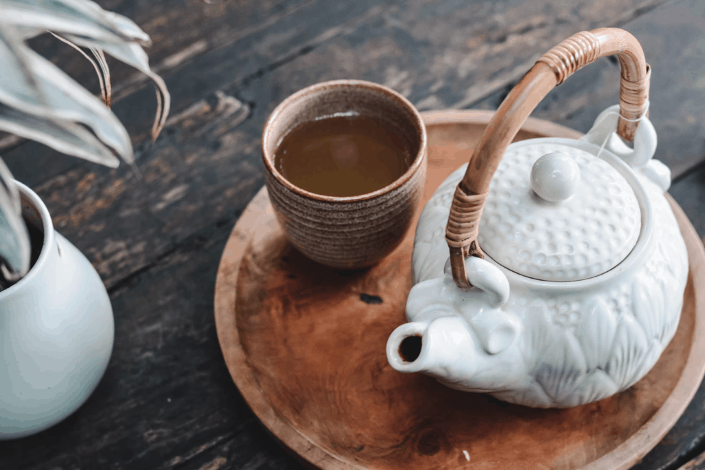 Stem tea in a cup with a tea pot