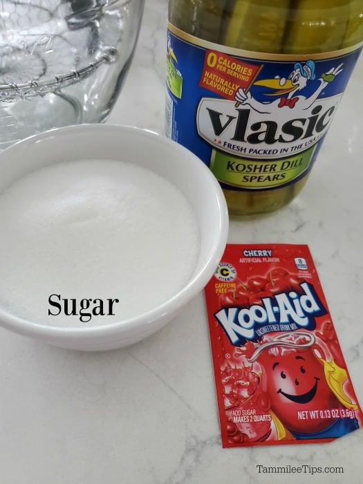 Kool Aid pIcks Ingredients - pickles in jar, sugar in white bowl and Kool cherry support pack