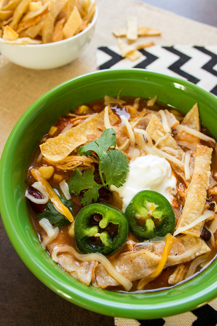 Close-up of a green bowl filled with slow cooker chicken tortilla soup