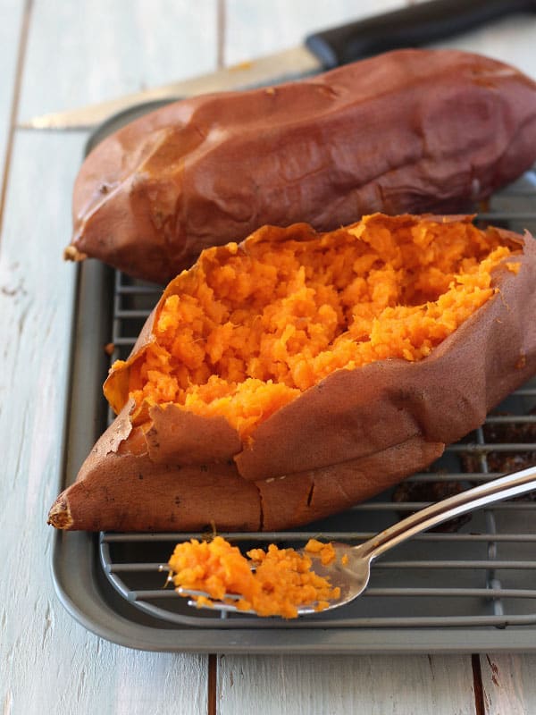 Baked sweet potato in a pan, thinly sliced ​​with the smooth orange peel inside exposed