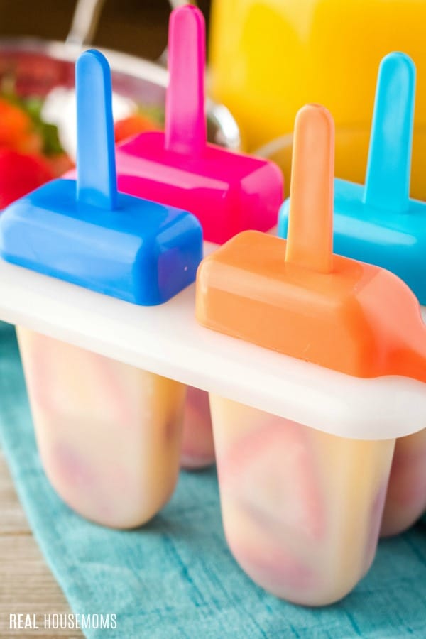 the ice orange juice pops out of the mold on the ice