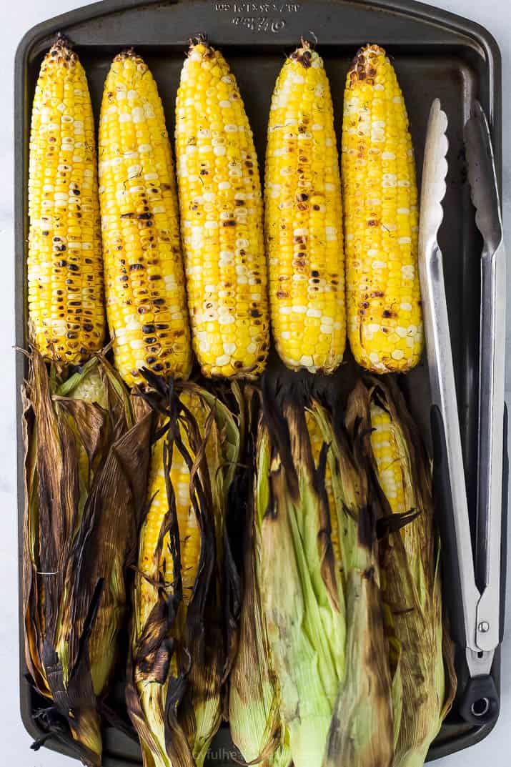 a baking sheet full of roasted corn on the cob
