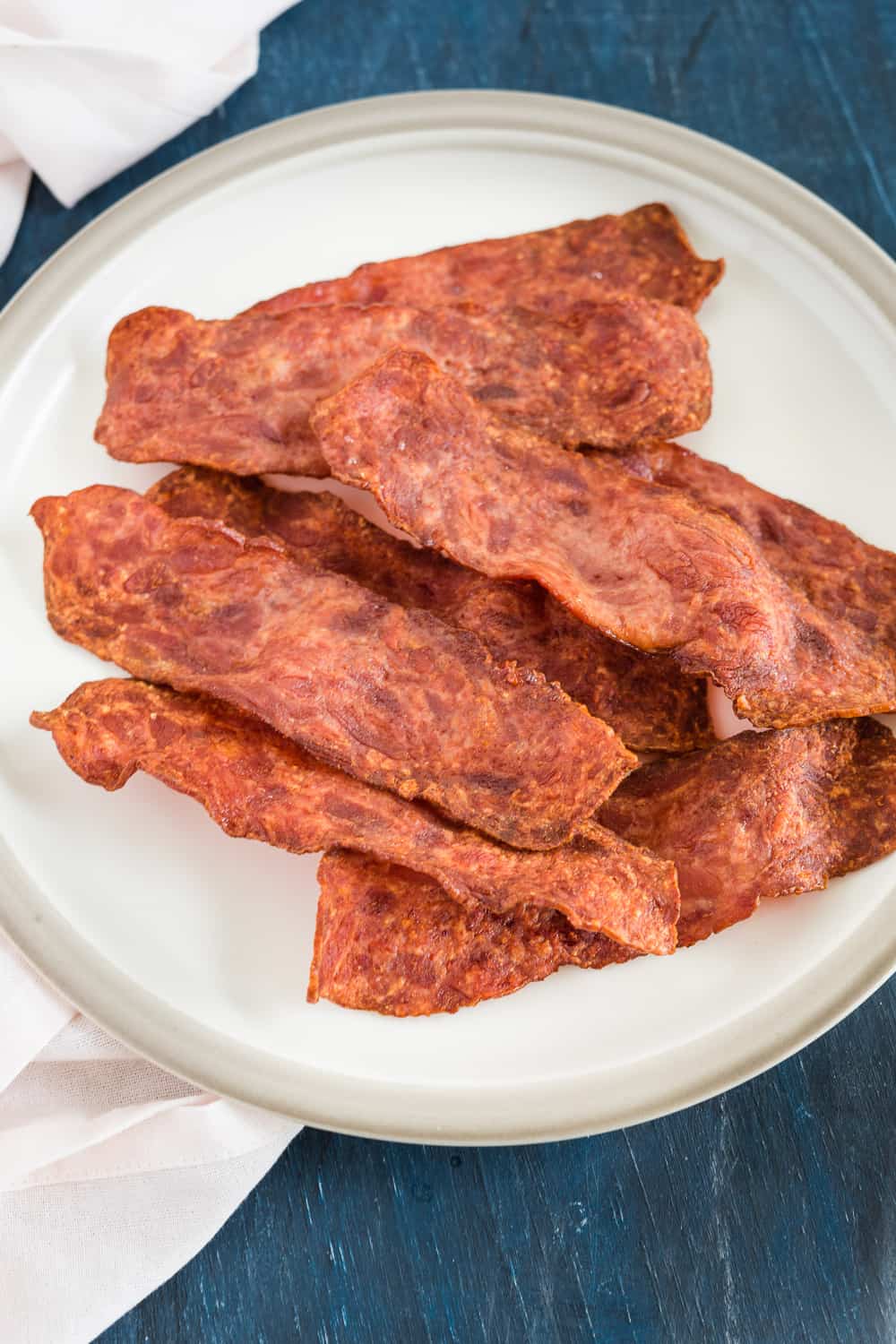 Keep a piece of cooked turkey bacon in the air fryer. the back has plates with other slices.
