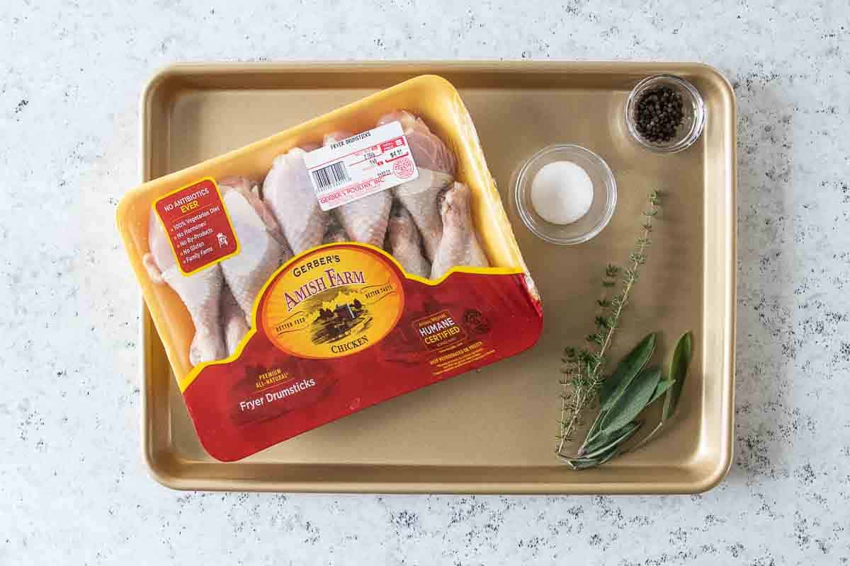 Raw chicken feet, herbs, pepper and salt on a baking tray