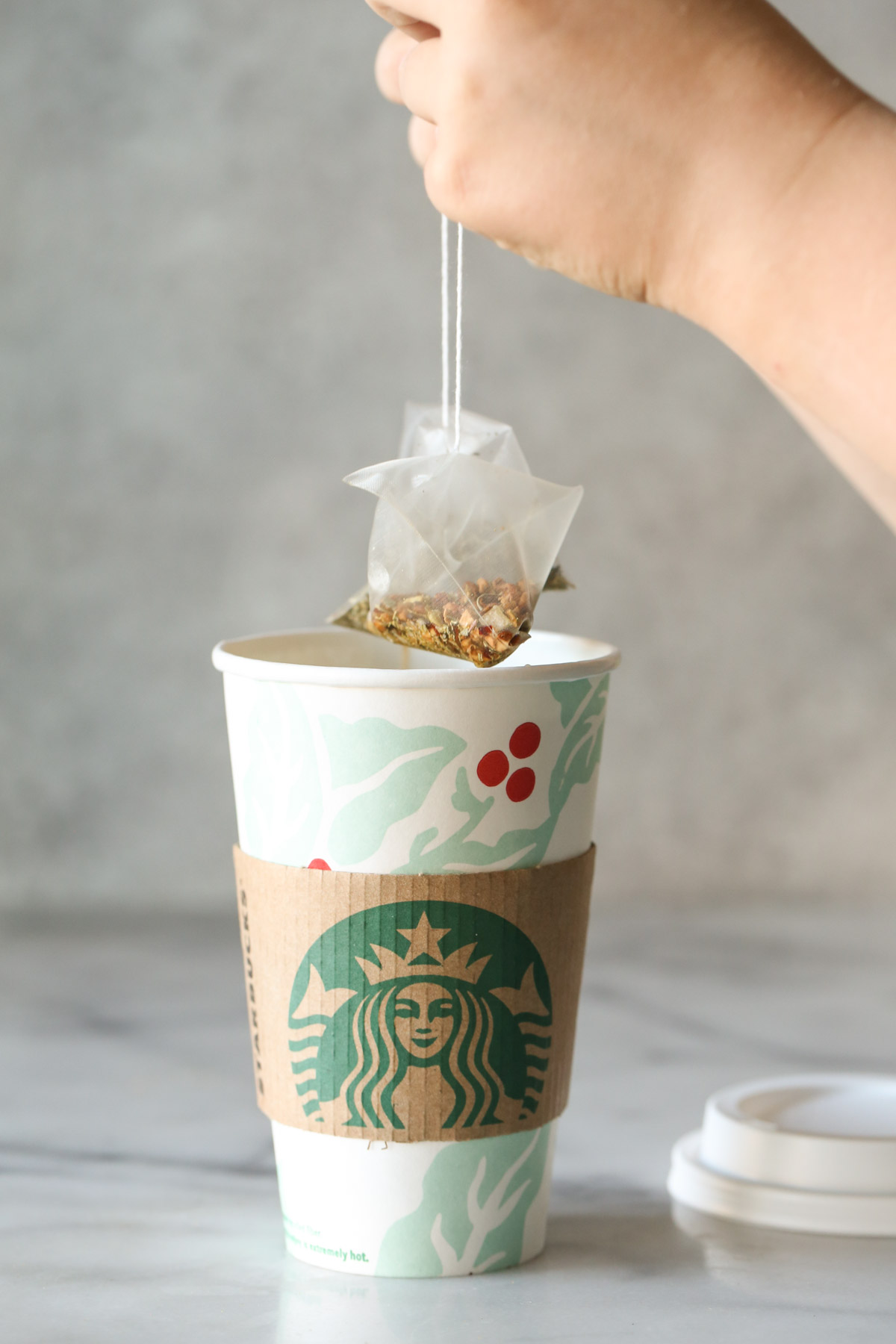Close-up shot of Starbucks Medicine Ball Tea in a hot Starbucks mug, with tea bags floating on top.