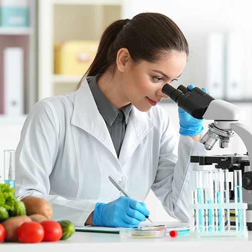 young female nutritionist testing food samples in a laboratory