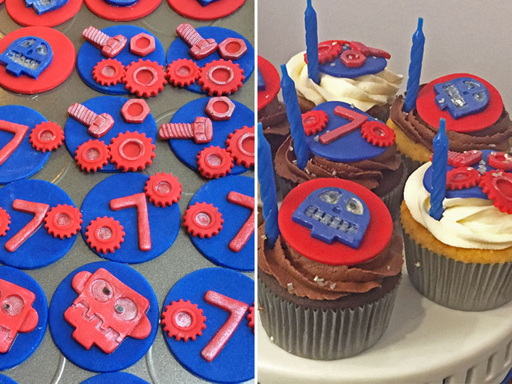 Robot-themed cupcakes are displayed alongside cupcakes topped with cupcakes.