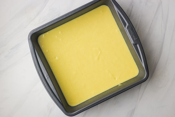 Cake batter in an 8x8 baking pan.