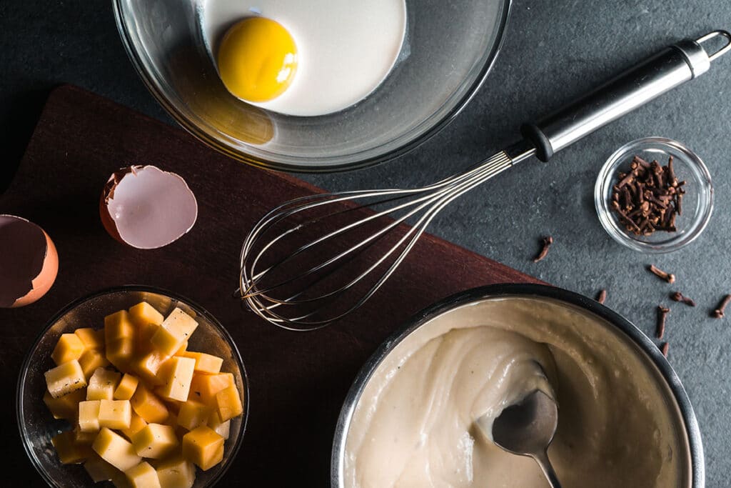 When you make your roux with white flour and butter and then add the milk and cheese, the sauce can become a little gritty. It could be caused by the type of cheese you are using, or it could be that you’ve had the heat too high, and it has denatured the protein.