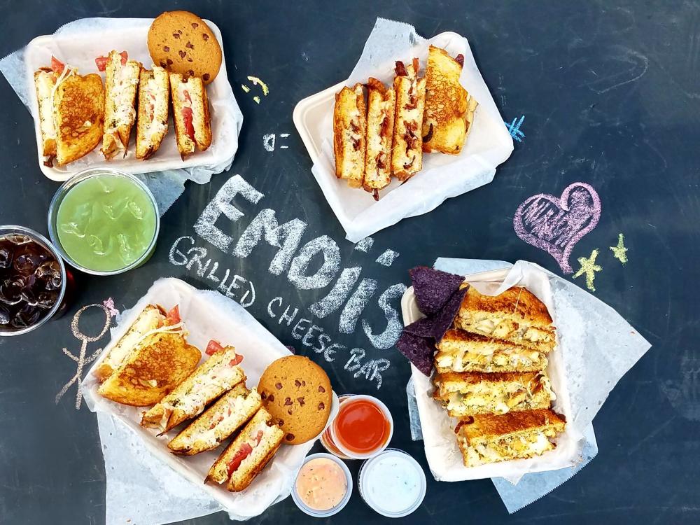 Four sandwiches with cookies and drinks from the Emojis Bake Cheese Trailer in Austin Texas