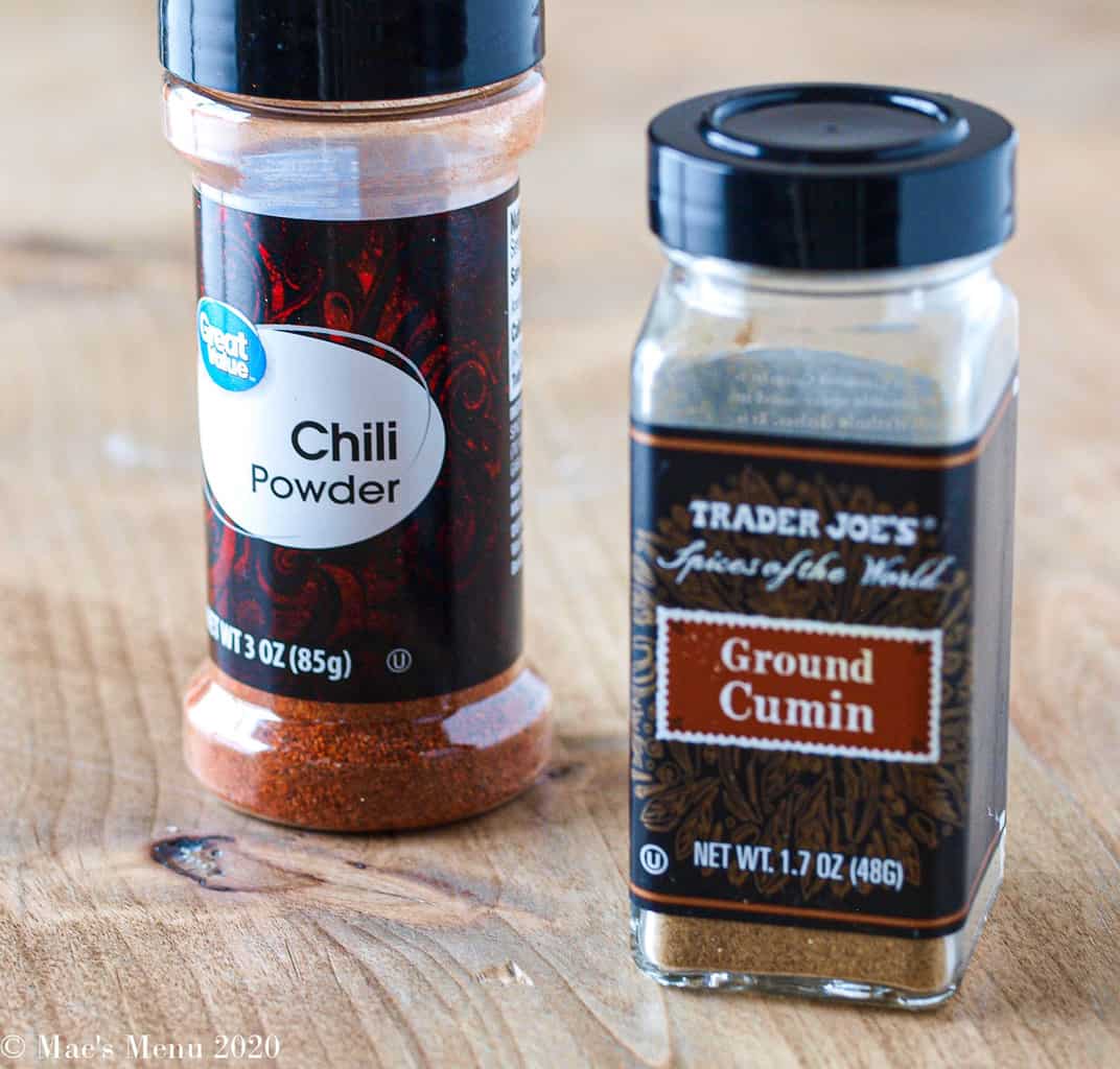 A bottle of paprika next to a bottle of ground cumin