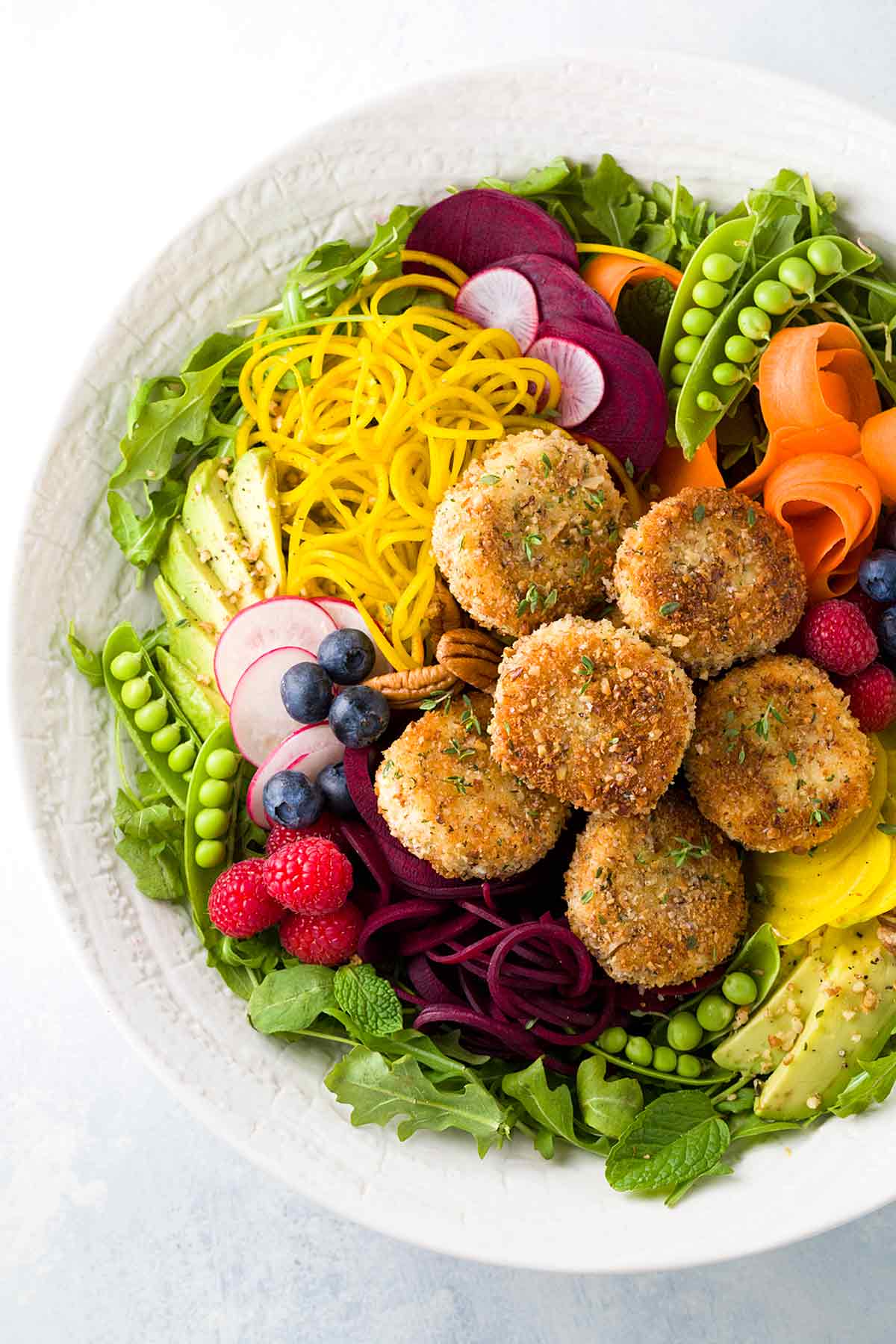 Crispy and delicious fried goat cheese salad recipe with fresh veggies, arugula, beets, carrots, peas, avocado and raspberry poppy seed sauce. | takeoutfood.best