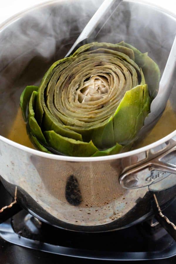 Grab the boiled artichoke cotton from the pot of water