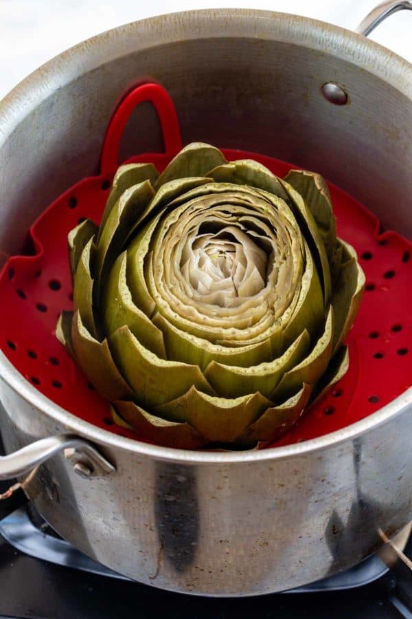 artichokes on a steaming basket in a pot