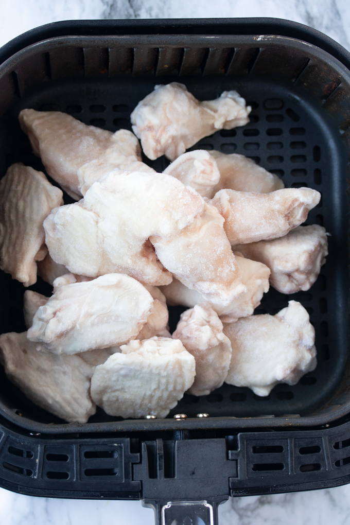 Frozen chicken wings in the air fryer basket