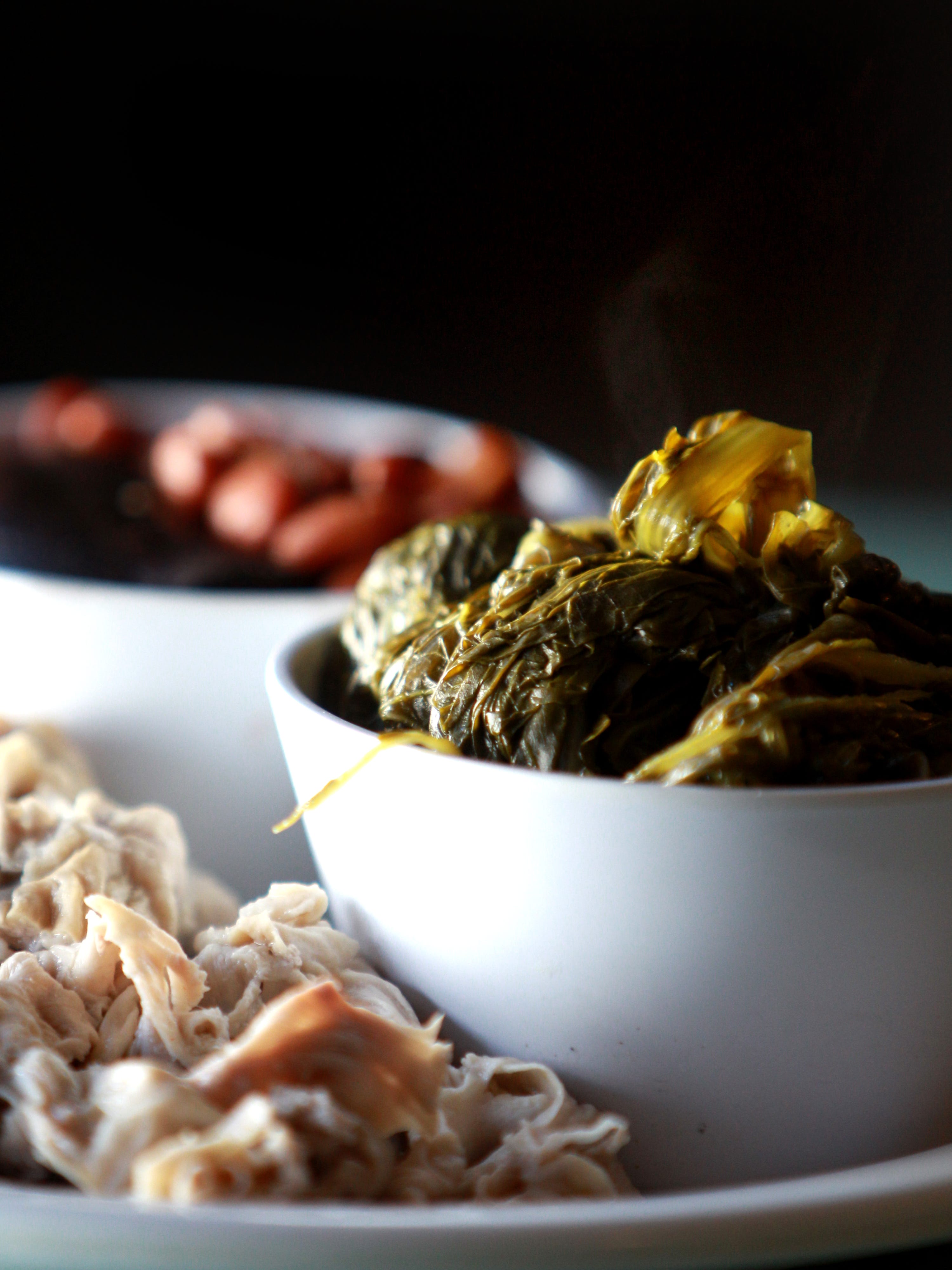 Steam rises from a bowl of greens served on a chili and beans dinner plate from the Orange Mound Grill.
