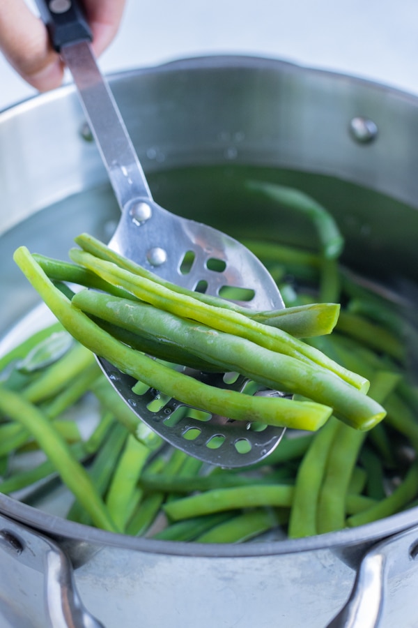 A slotted spoon is used to remove the beans.