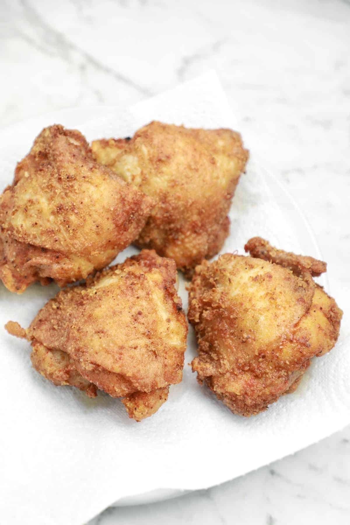 Place fried chicken thighs on a plate.