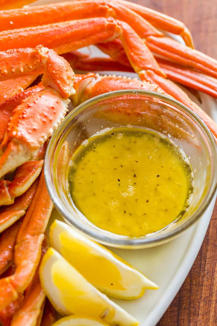 Crab dipping sauce with ramekin sauce surrounds the crab legs