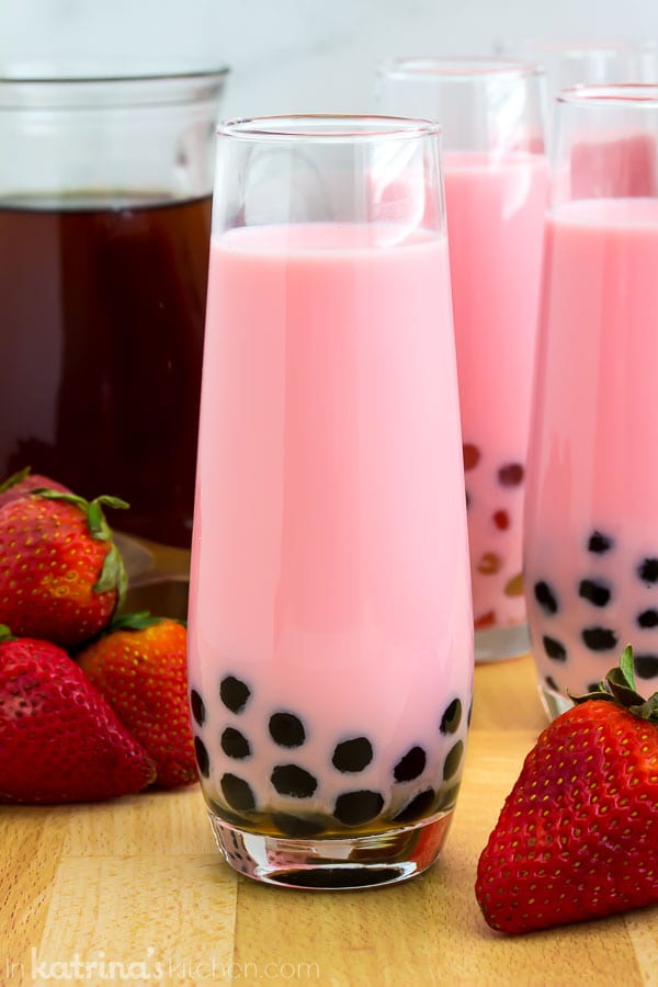 cup of strawberry pearl milk tea with black sugar pearls