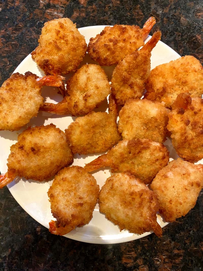Deep fried breaded shrimp on a white plate