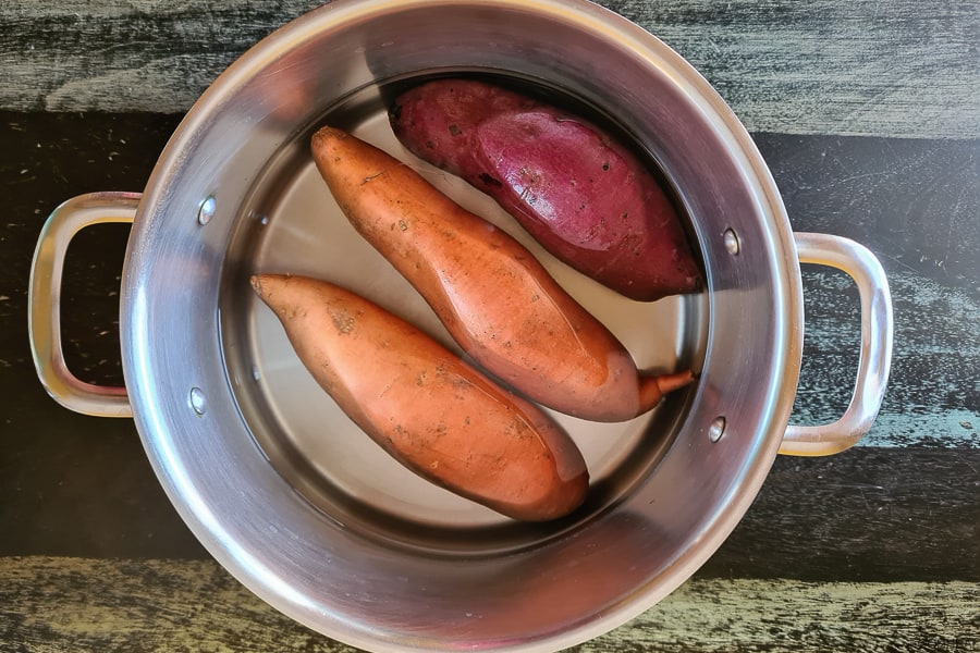 orange, purple & white potatoes in a pot