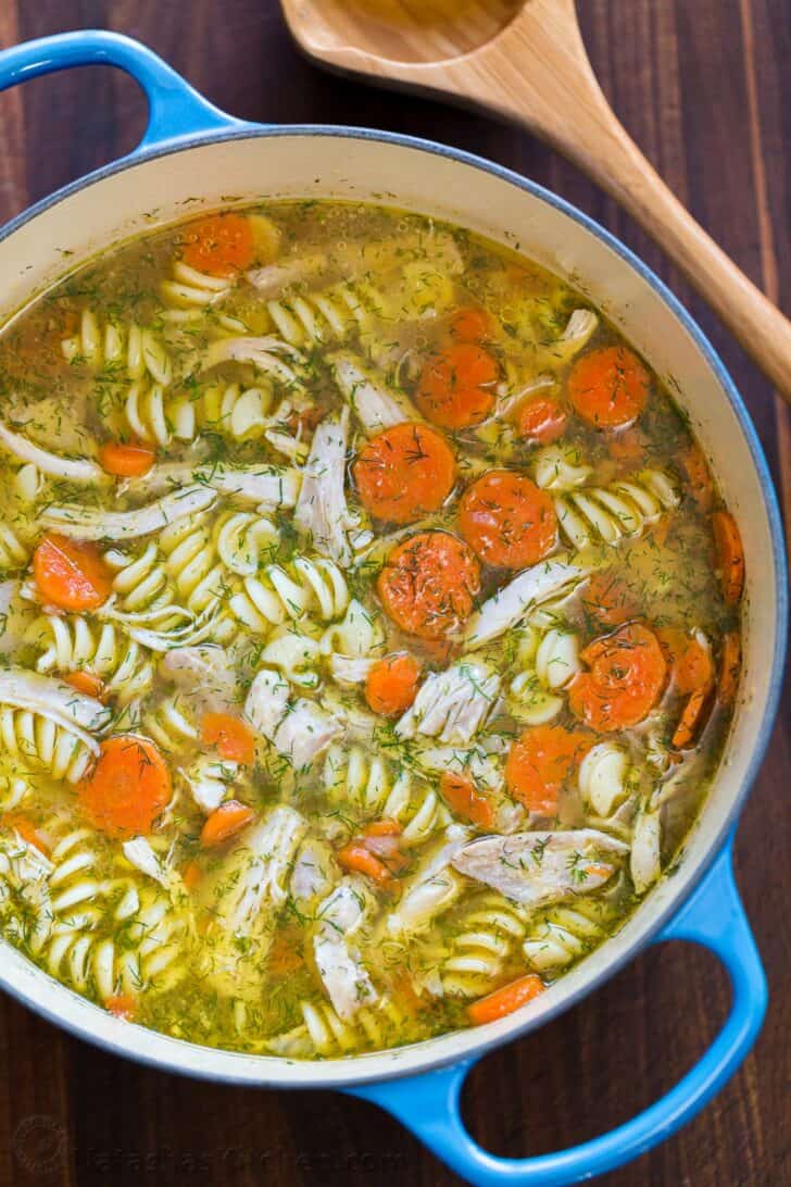 Easy Chicken Noodle Soup is ready to serve with dill and freshly pressed garlic