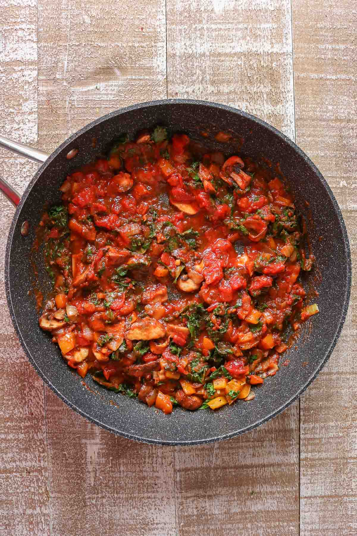 Vegetables and pasta sauce in a pan.