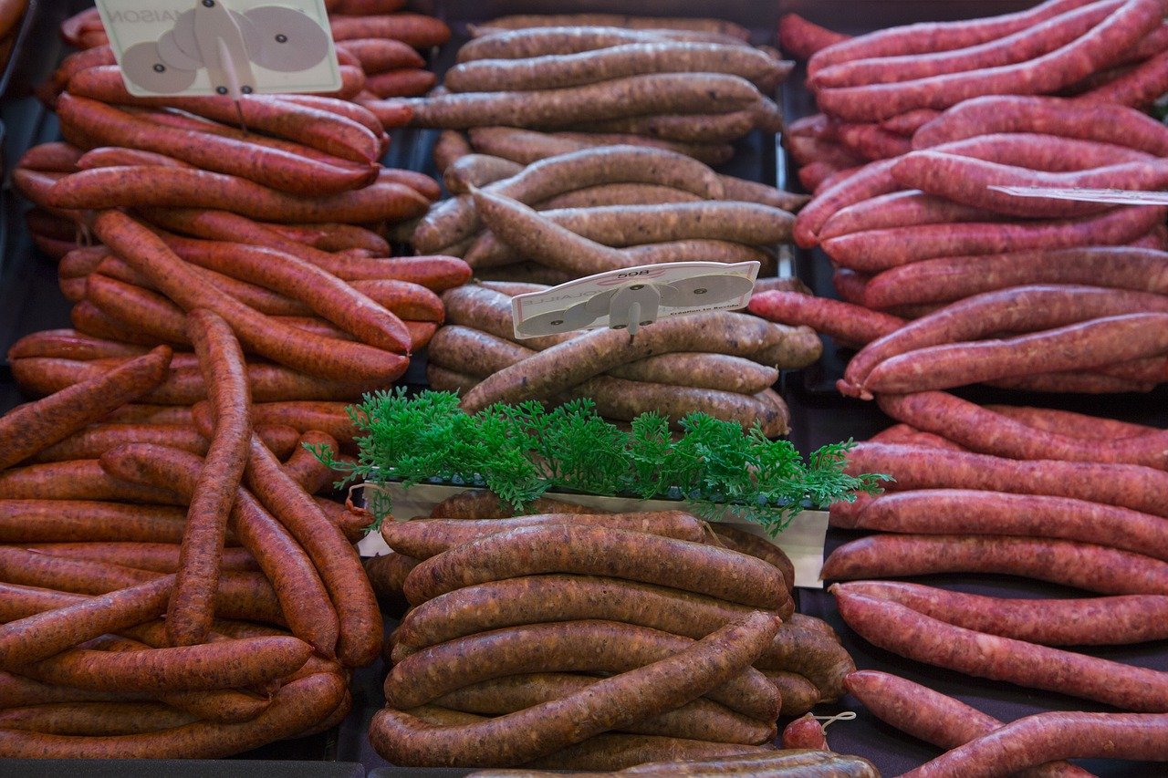 a meat market or butcher case full of raw bratwurst