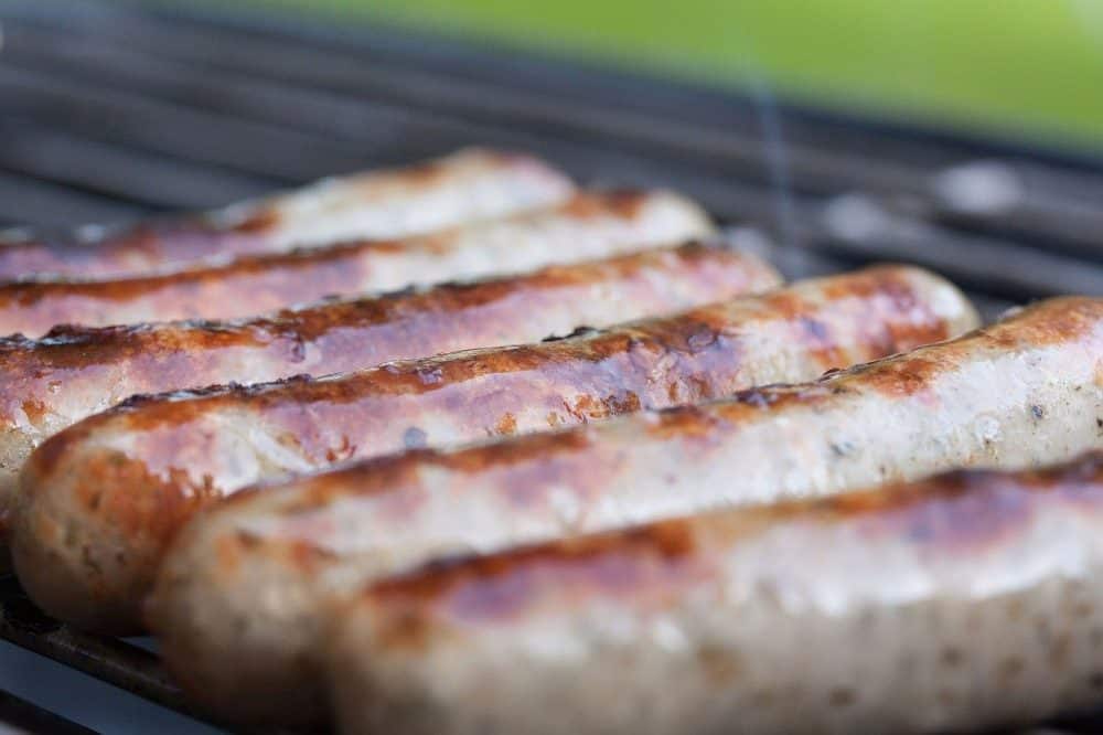 brats being grilled o a propane grill