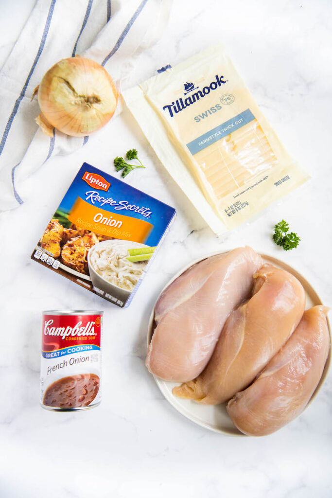 Ingredients arranged on the counter with chicken breast on a plate.
