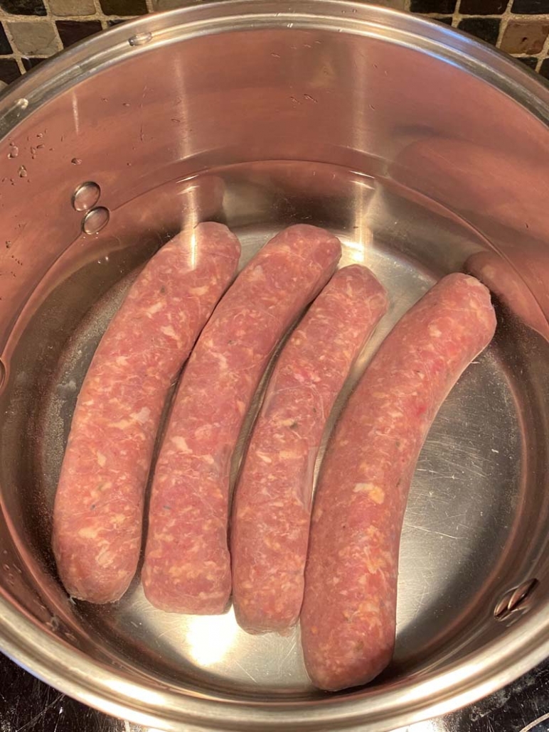 raw italian sausage in a pot of water