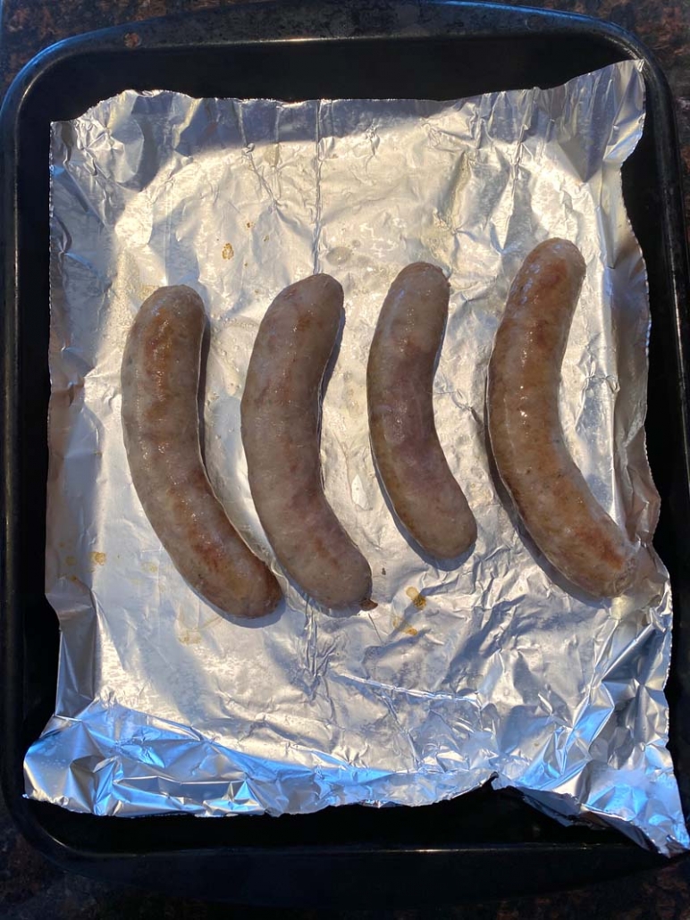 Grilled boiled sausage on a foil pan