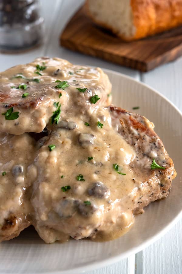 White plate includes 5 pieces of grilled pork with mushroom cream sauce