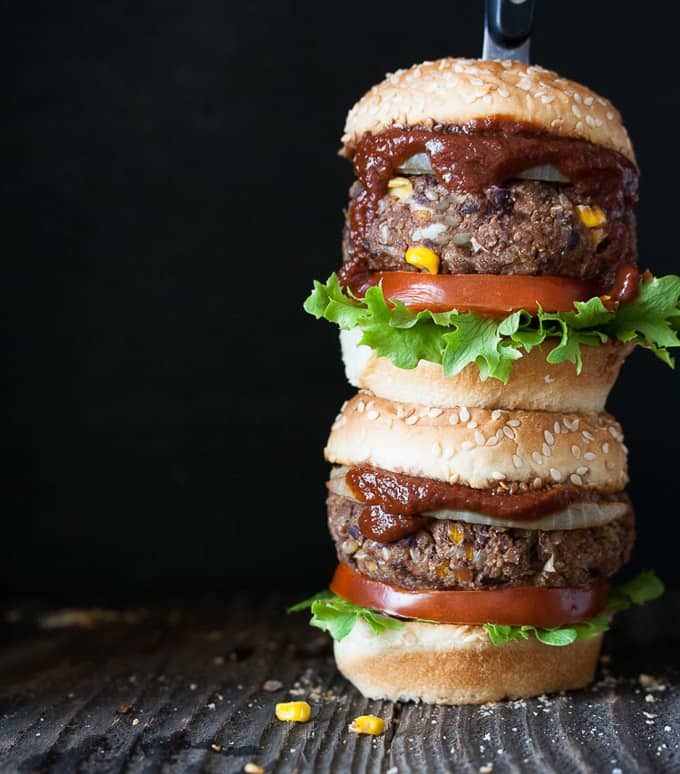 a stack of vegan black bean burgers with a black background