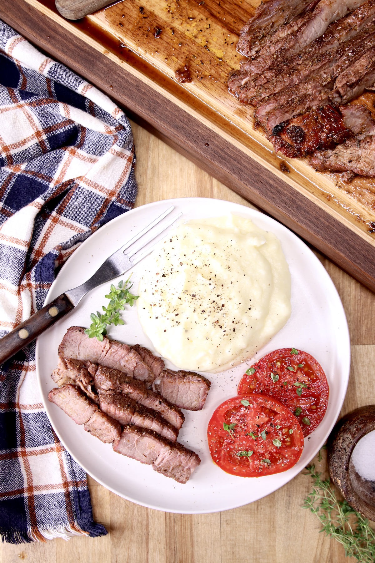 Plate of sliced ​​grilled meat, mashed potatoes, sliced ​​potatoes