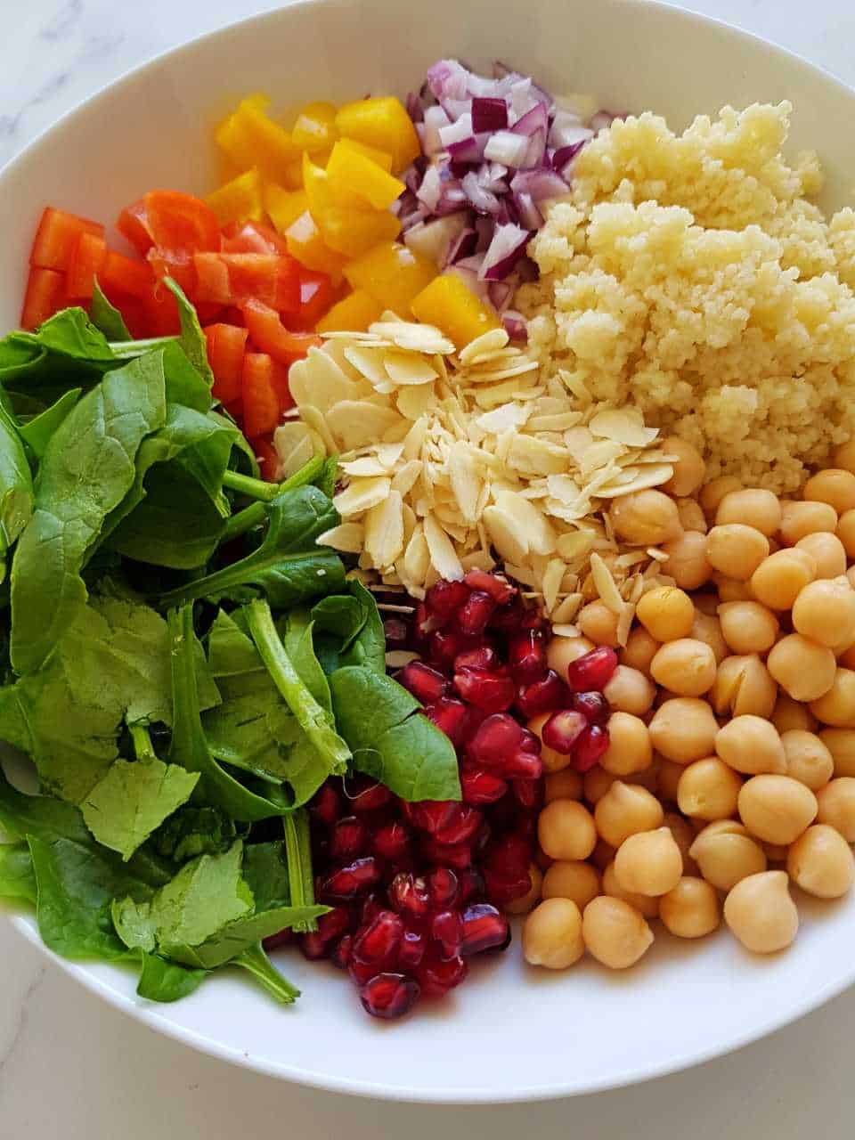 Couscous salad ingredients in a white bowl - do not mix together.
