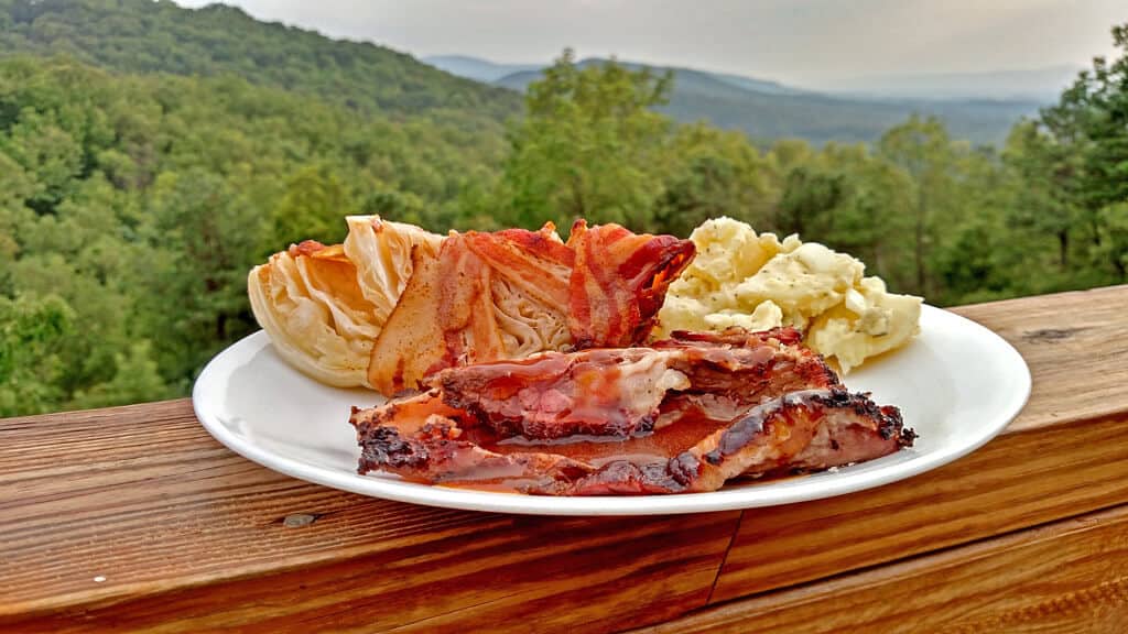 Thinly sliced ​​beef brisket with sides on a plate overlooking the mountains
