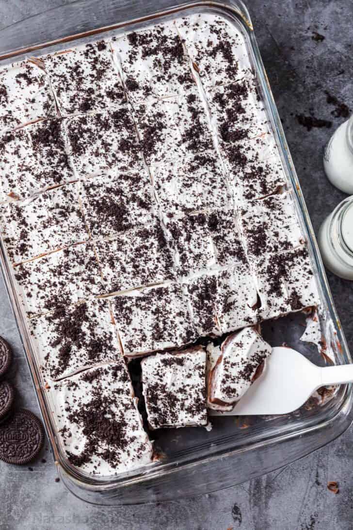 Chocolate lasagna in a casserole dish with crushed oreo cookies.