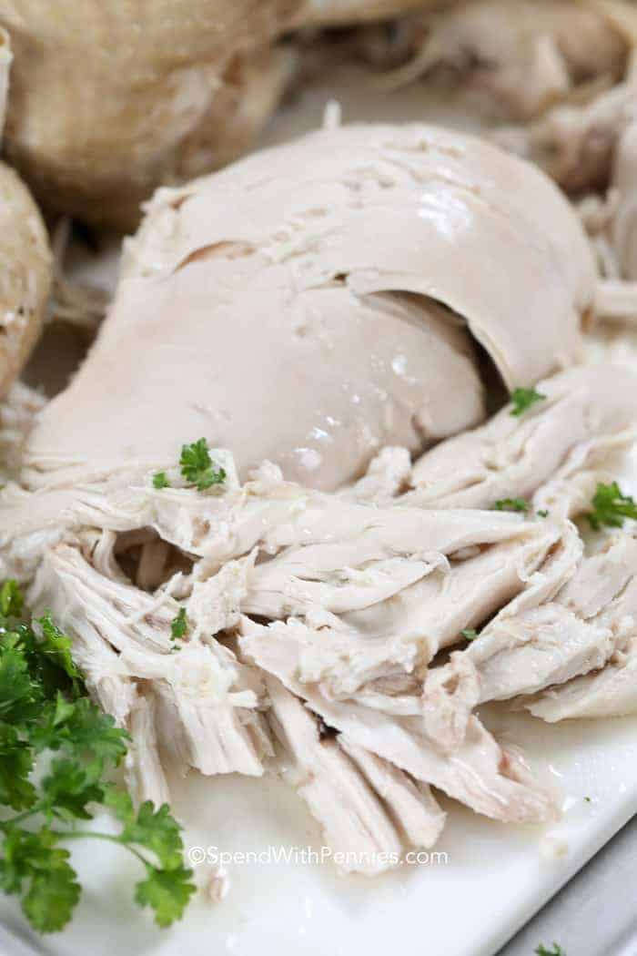 Boiled chicken on a cutting board with parsley