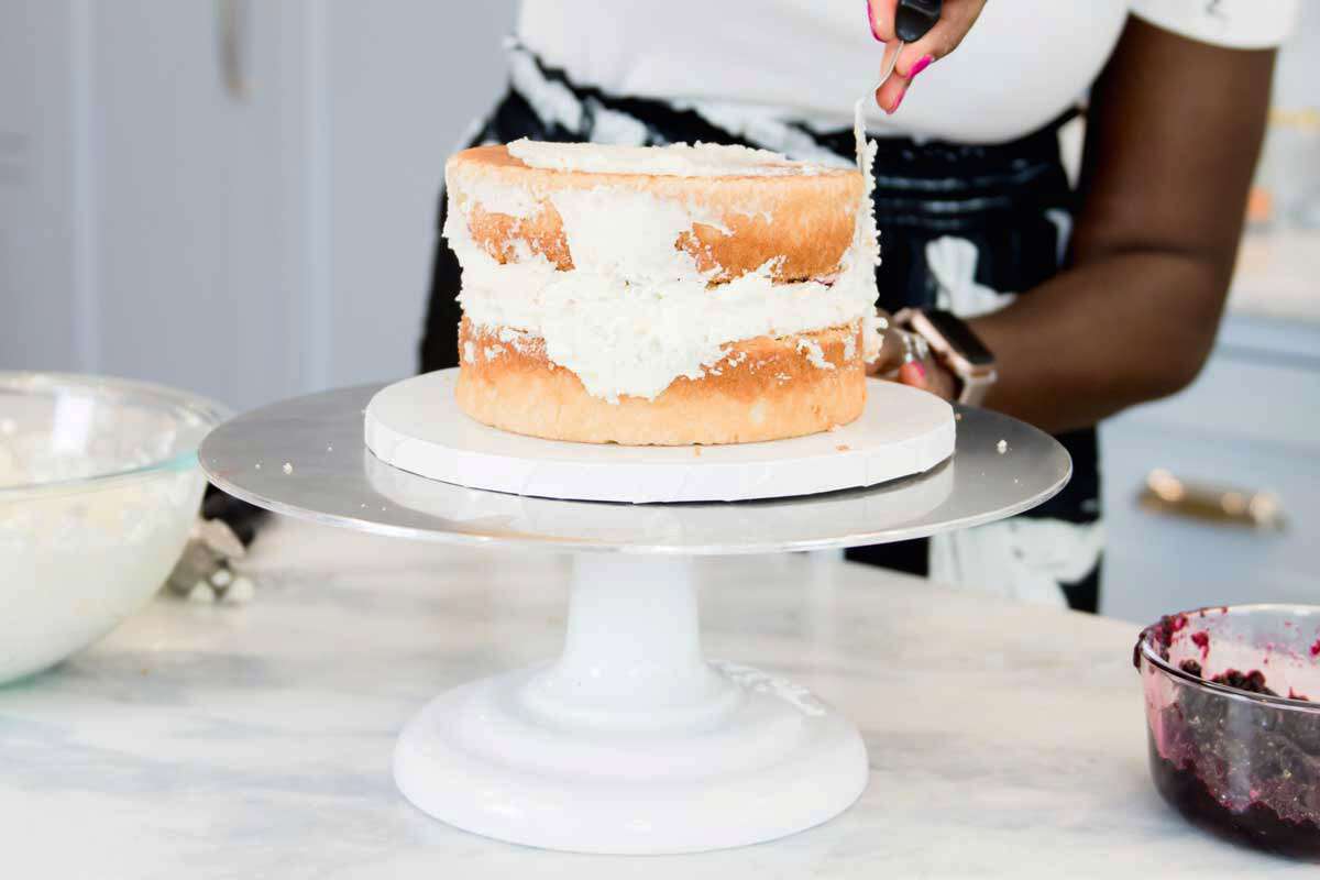 Zainab smooths the toppings on the cake