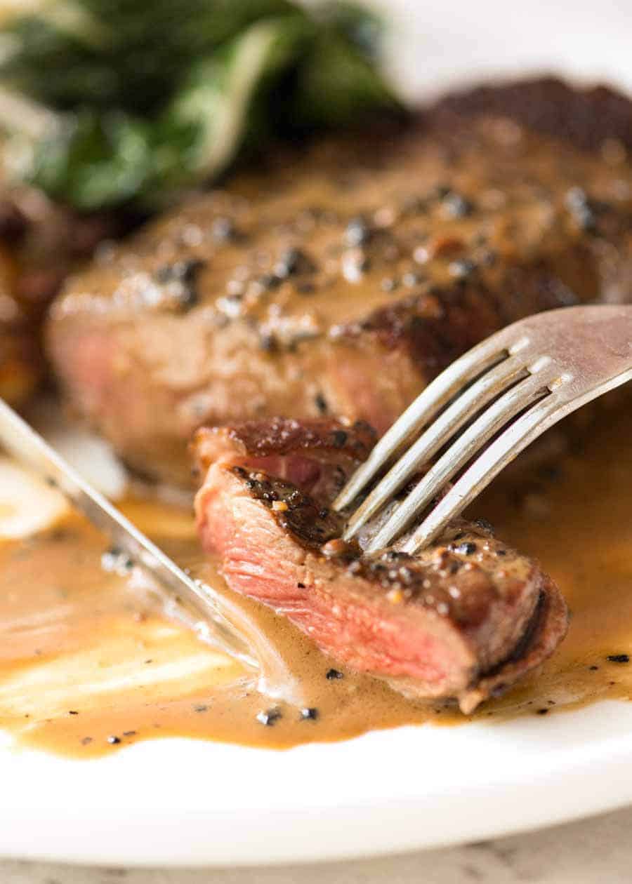 Close-up of a fork and a knife to eat a piece of Steak with Pepper Cream Sauce