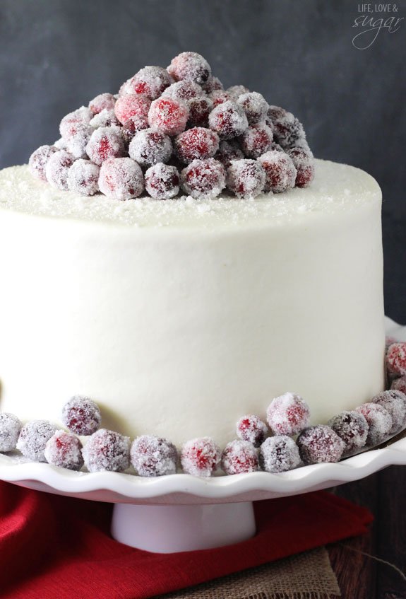 Sparkling Cranberry White Chocolate Cake - super moist vanilla cake full of fresh cranberries, iced with white chocolate icing and topped with sparking cranberries!