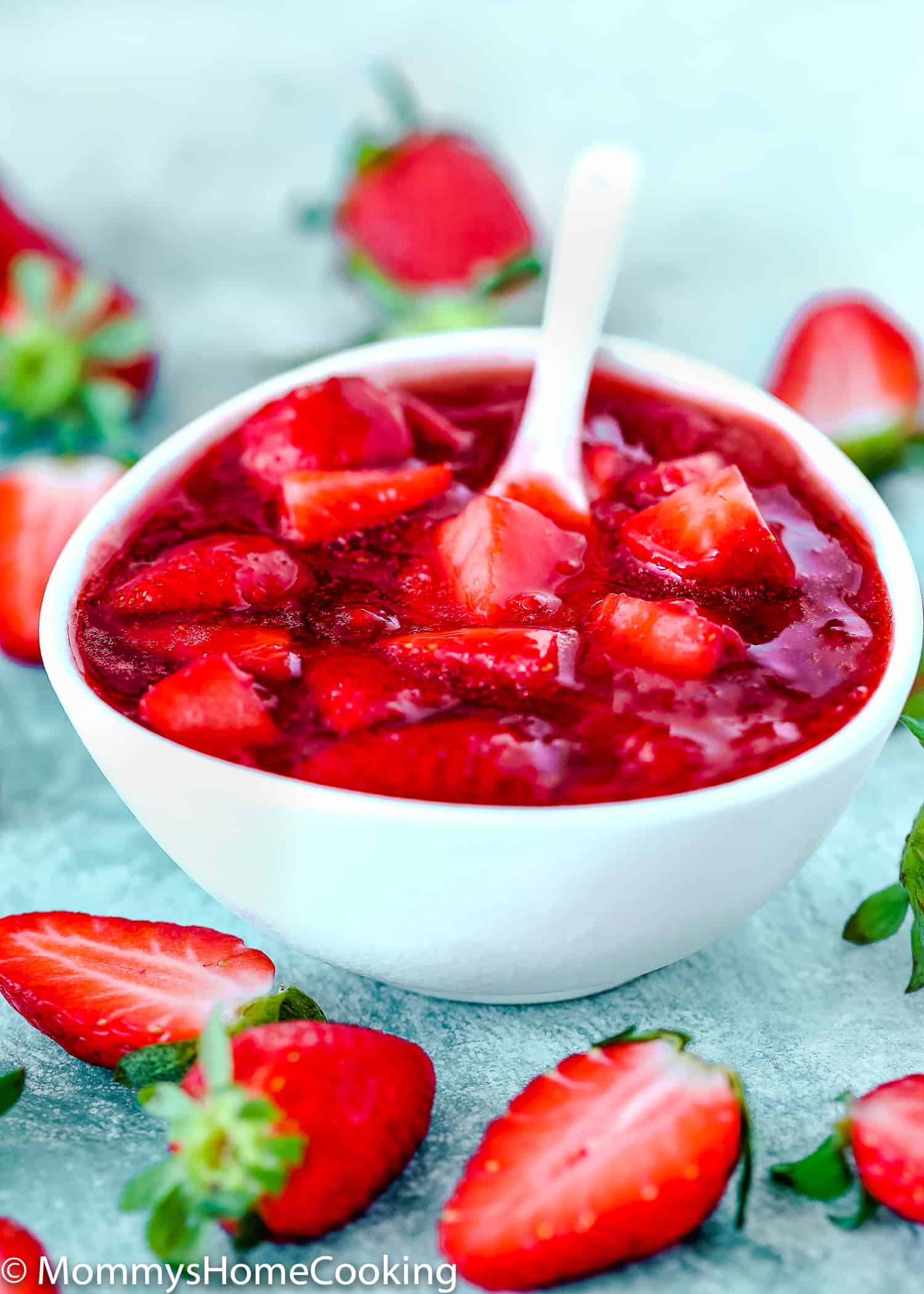 Strawberry sauce / topping in a white bowl and fresh strawberries