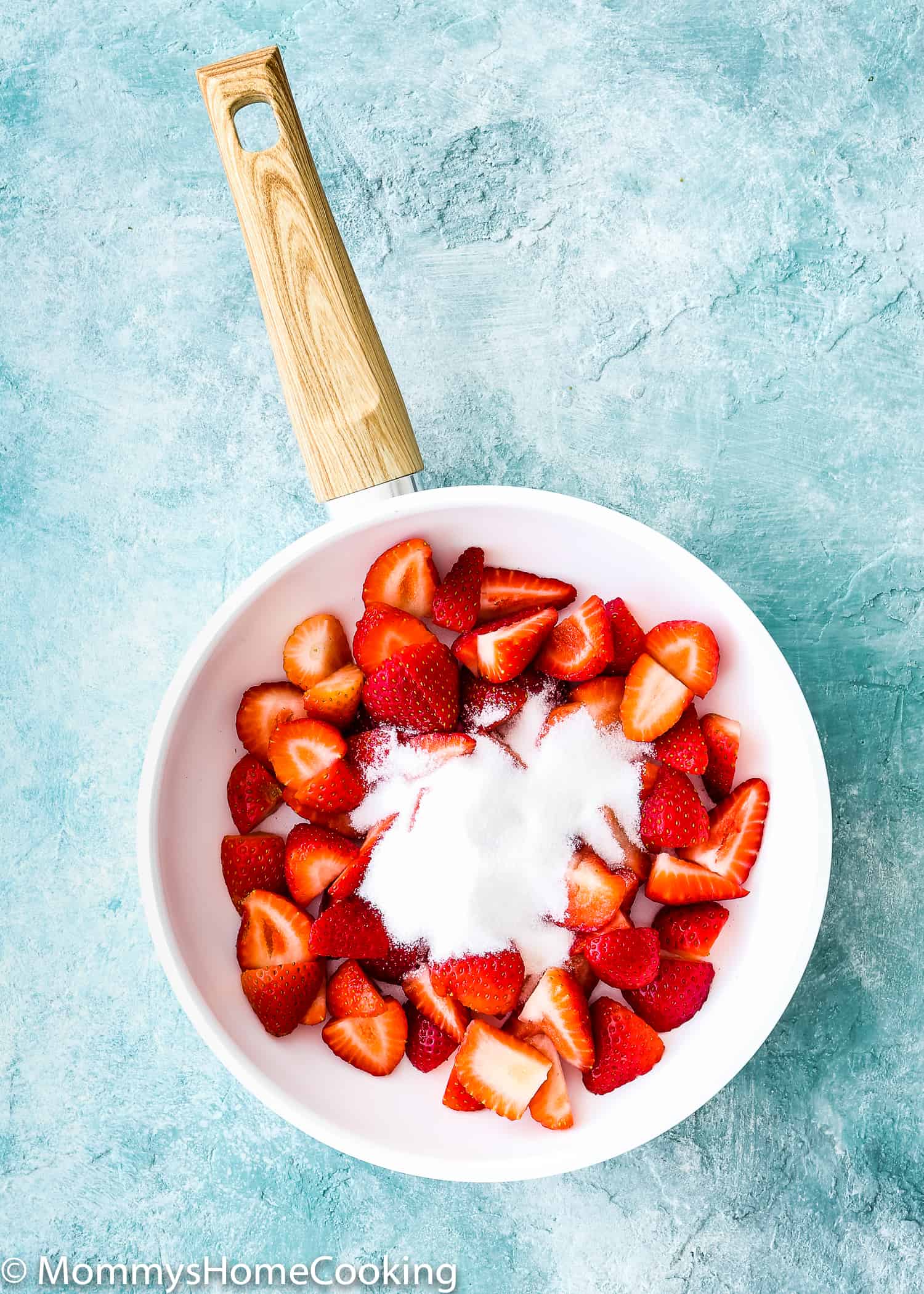 white pan with chopped strawberries and sugar