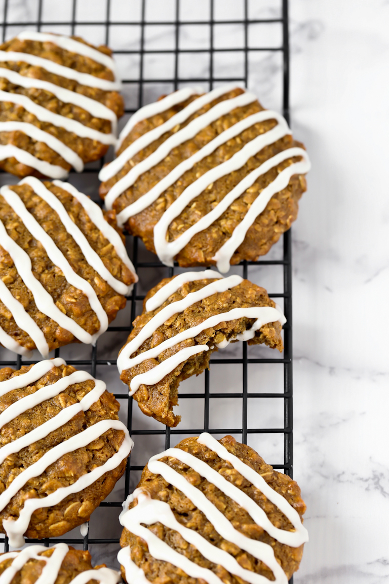 some vegetarian iced oat cookies with drizzle on a cooling rack