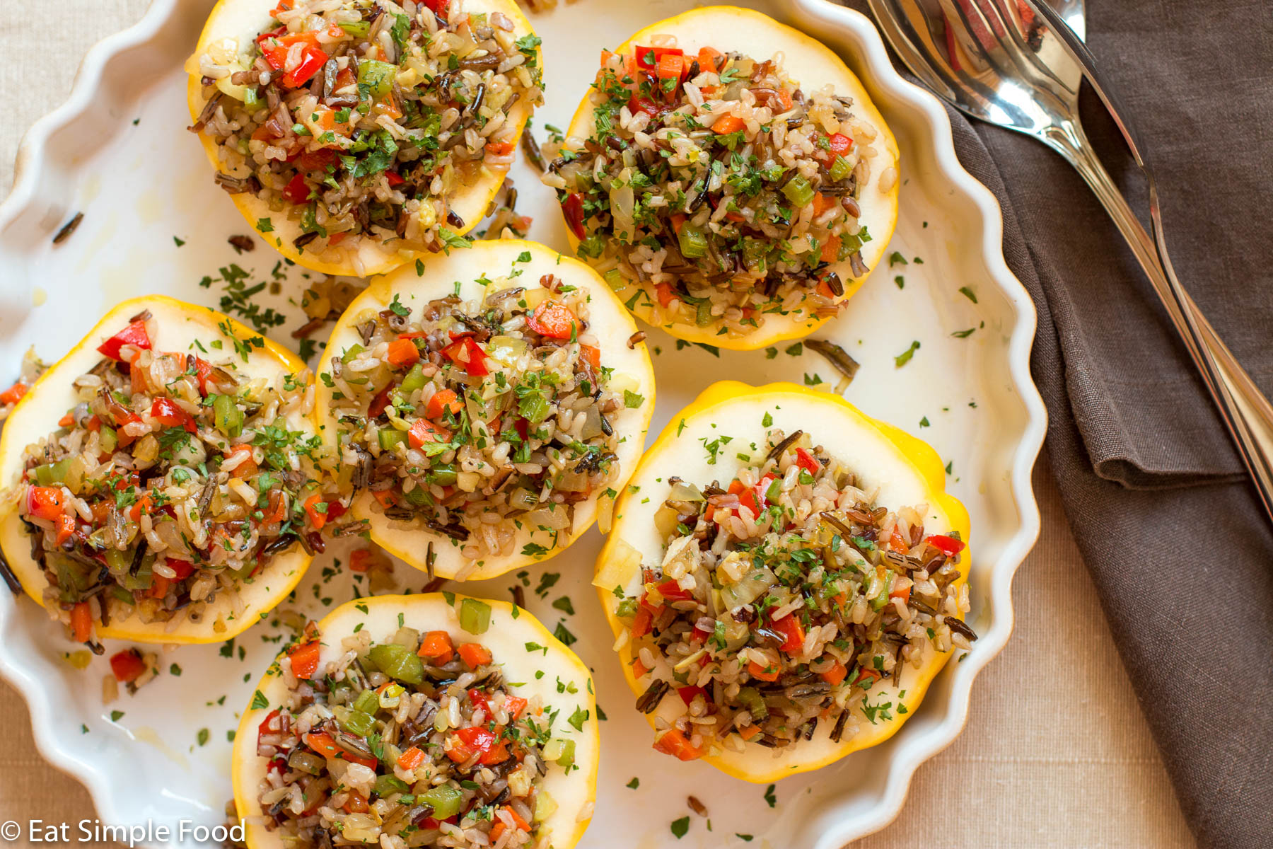 Patty Pan w Stuffed with Wild Rice, Red Pepper, Onion, Celery, Carrot and Herbs. Top view in a shallow baking dish