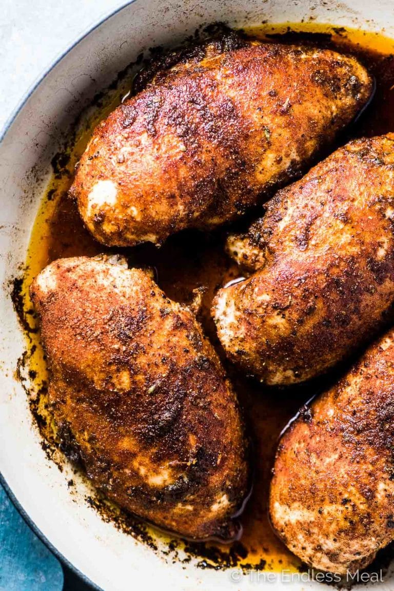 A pan of juicy grilled chicken breasts in a baking dish.